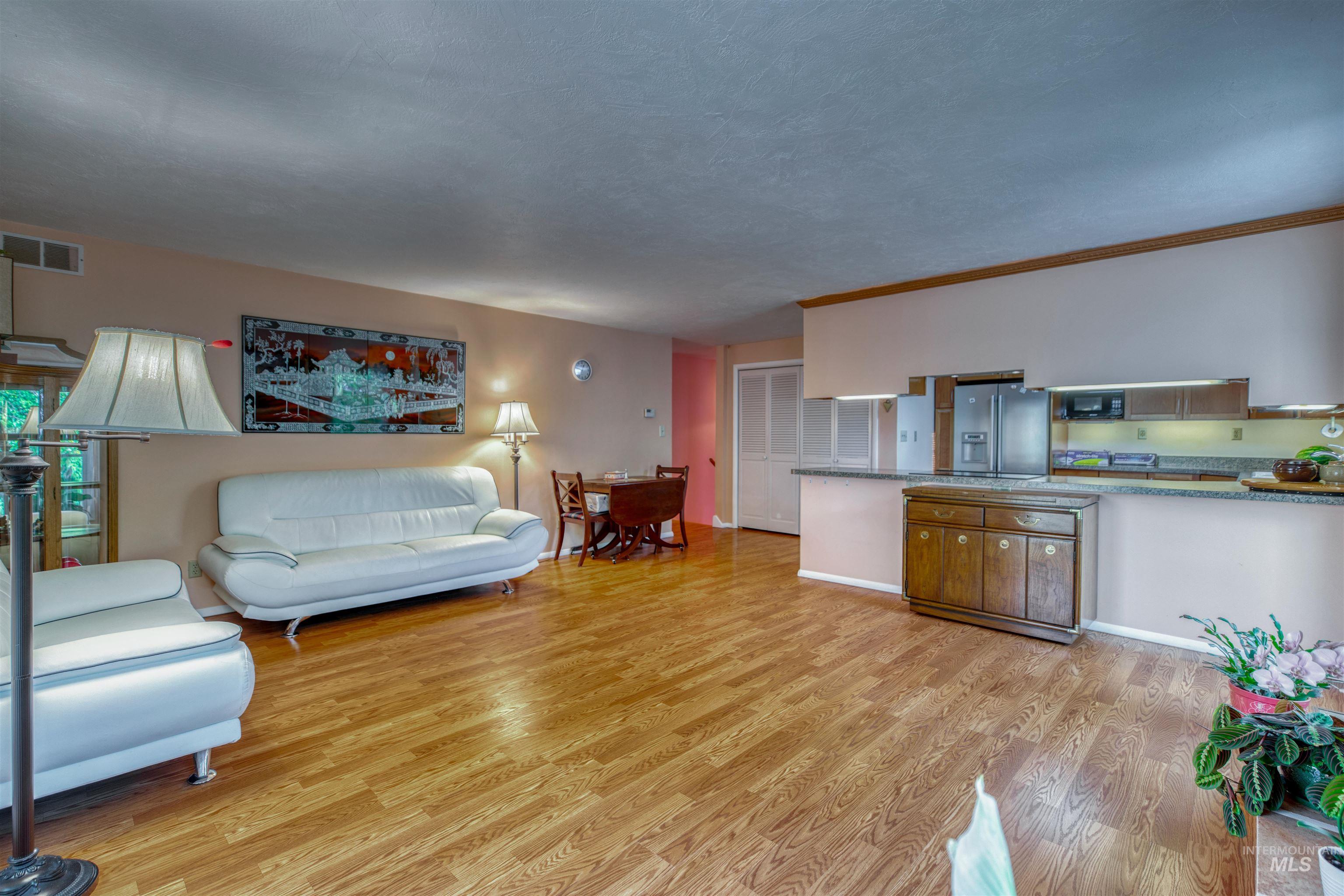Living area with light wood finished floors and a textured ceiling