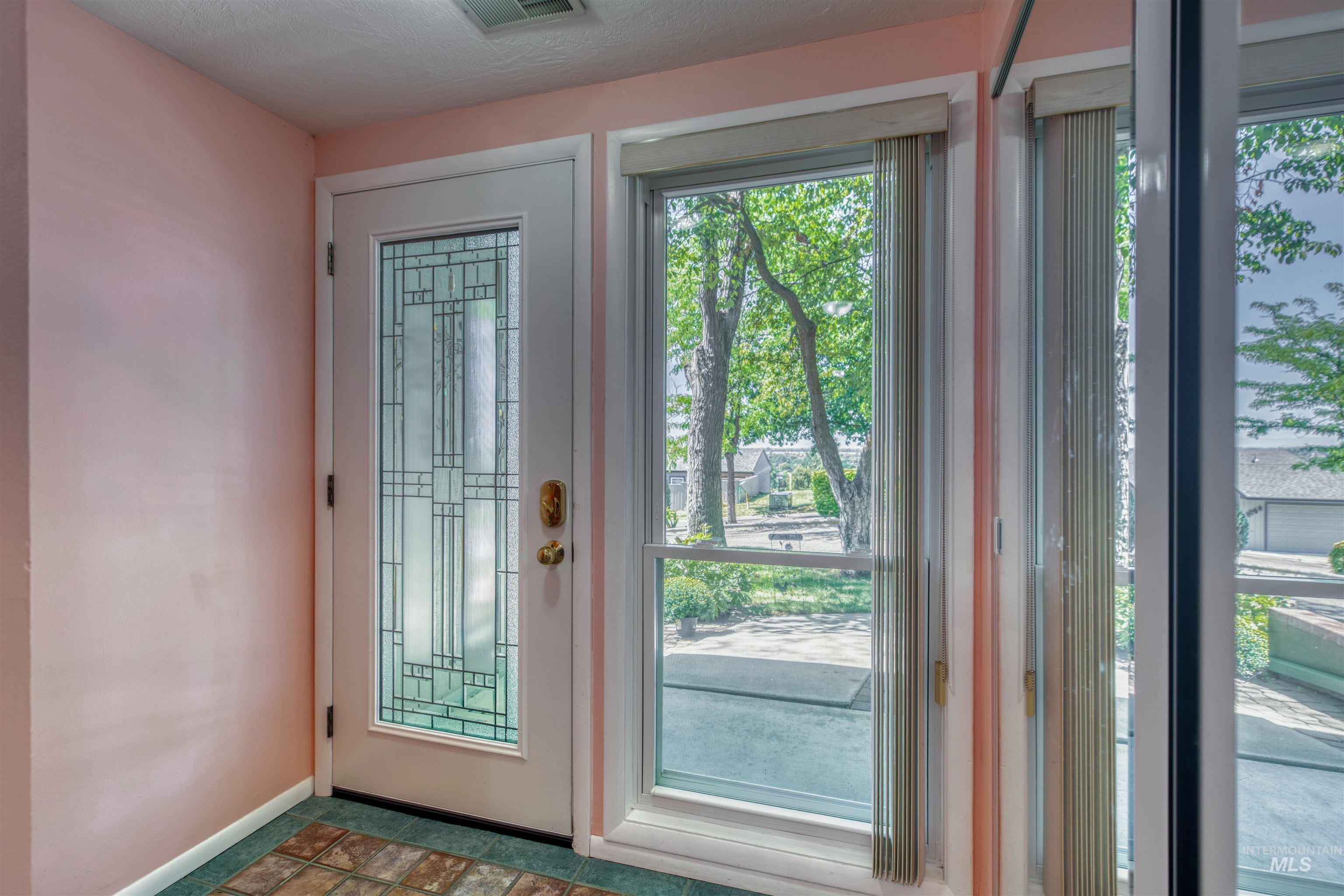 Doorway to outside with baseboards and a textured ceiling