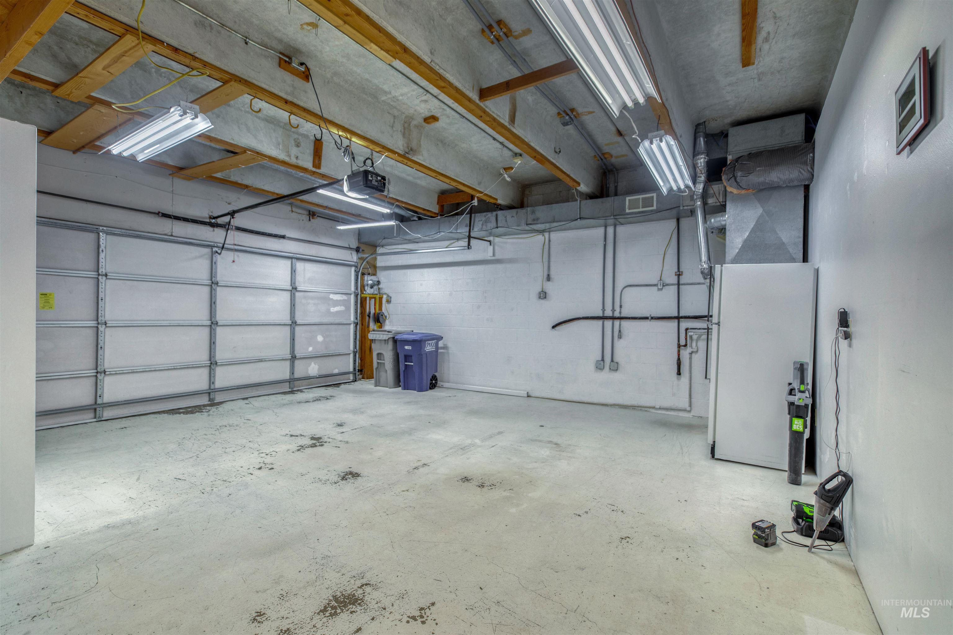 Garage with a garage door opener, concrete block wall, and heating unit