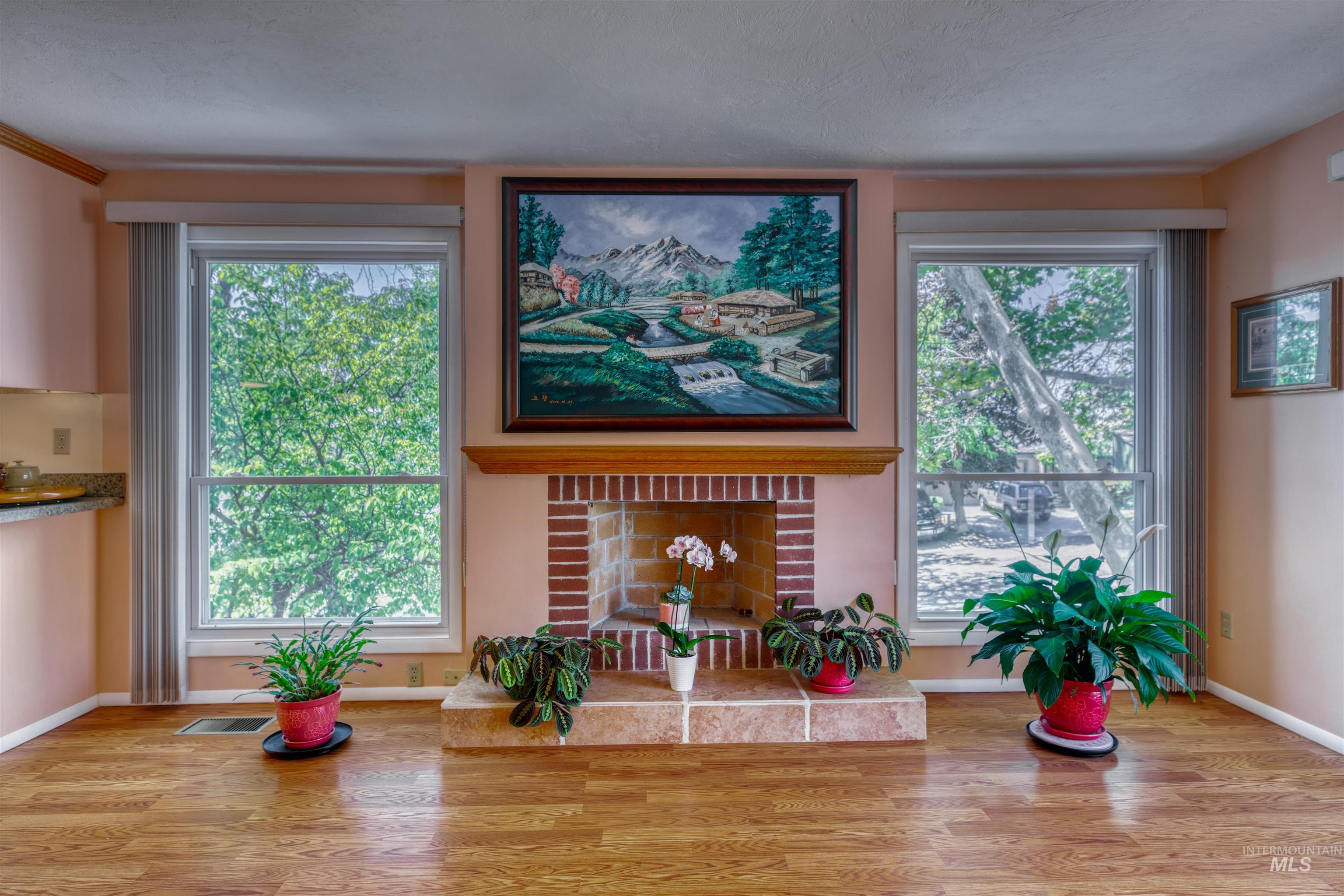 Detailed view of wood finished floors and a brick fireplace