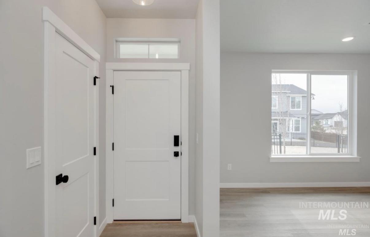 Foyer entrance featuring plenty of natural light and light wood-style floors