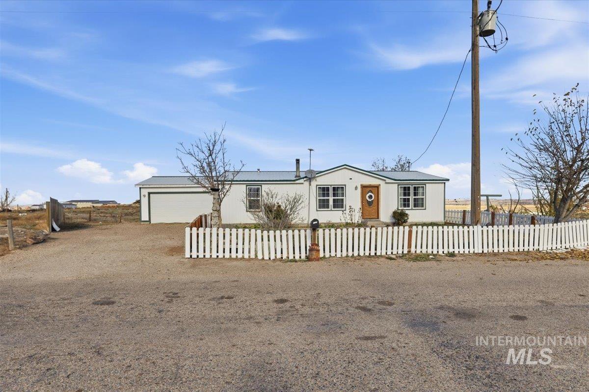 Manufactured / mobile home with a fenced front yard and driveway