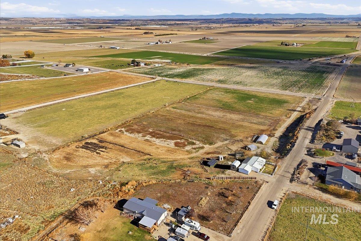 Aerial view of property's location with rural landscape and a mountainous background