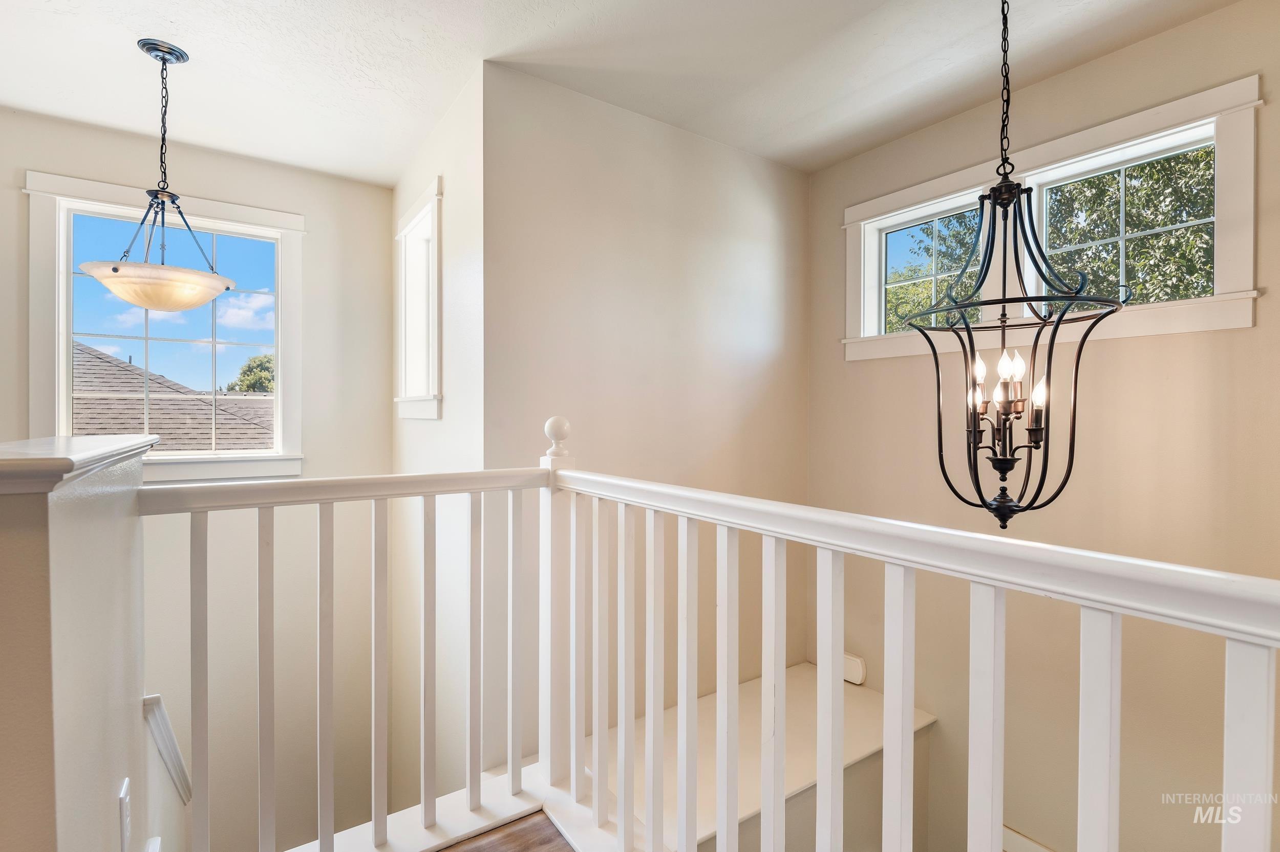Hallway featuring a chandelier and an upstairs landing