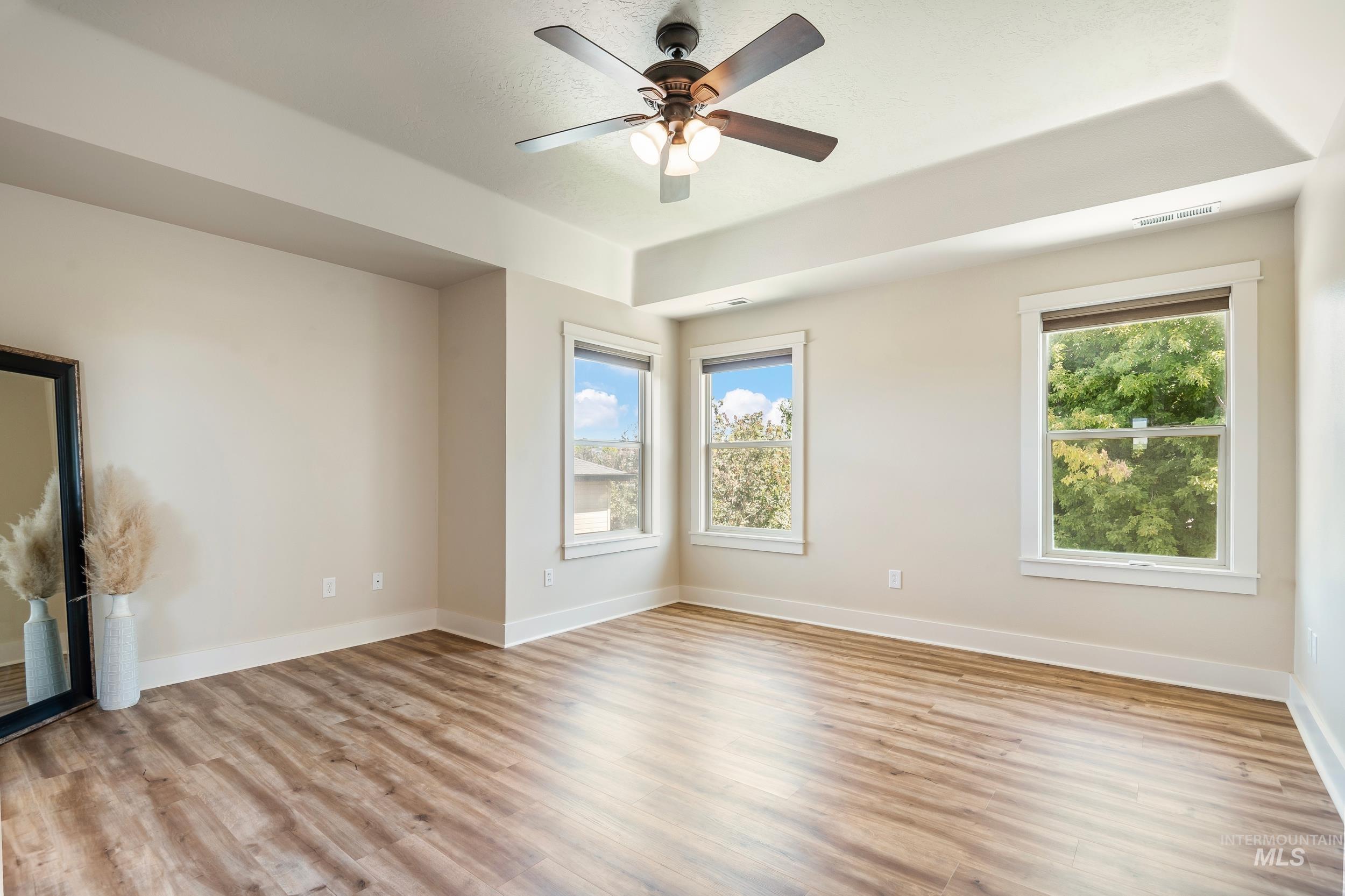 Empty room with light wood-type flooring and ceiling fan