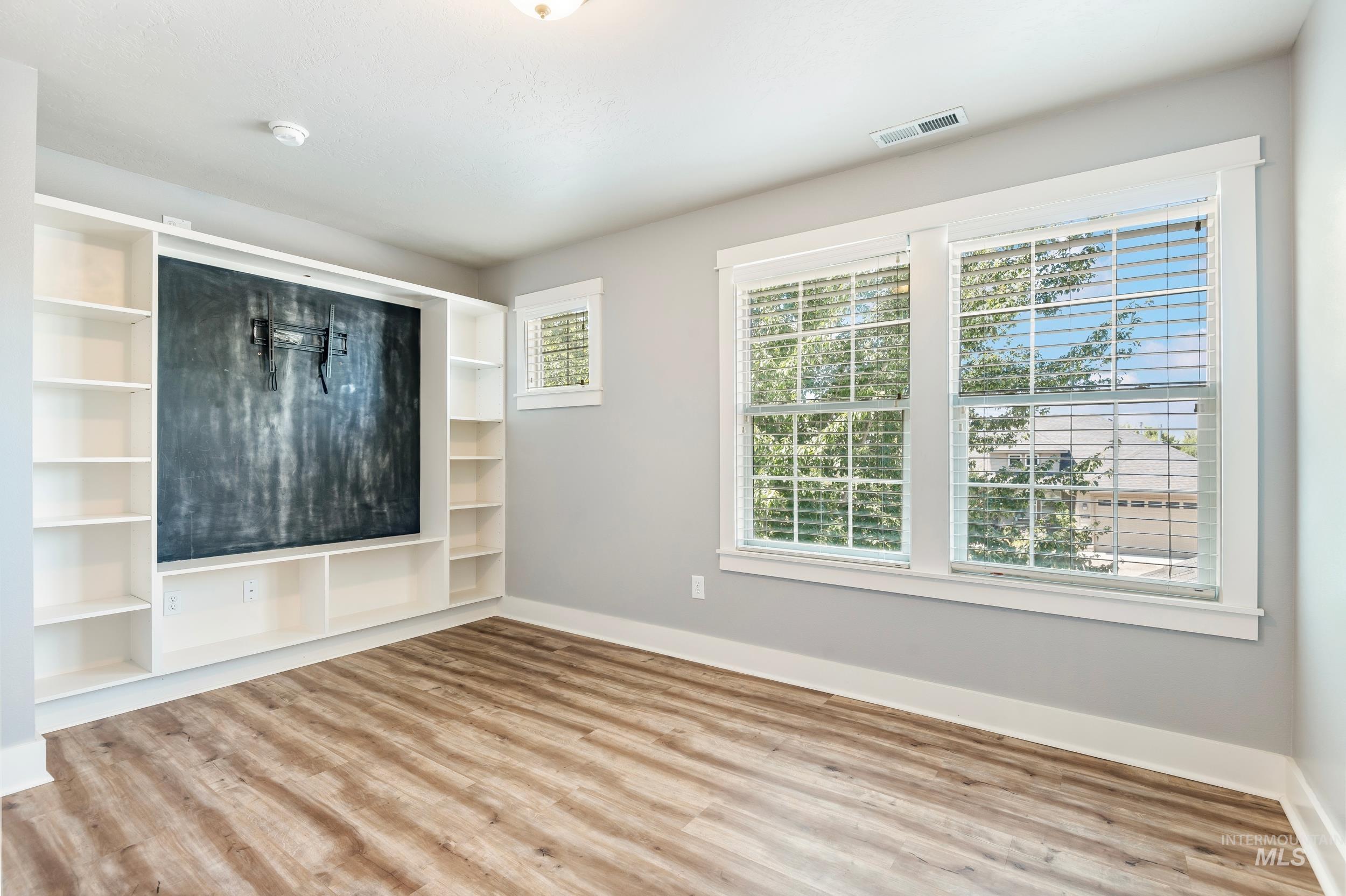 Spare room featuring baseboards and wood finished floors