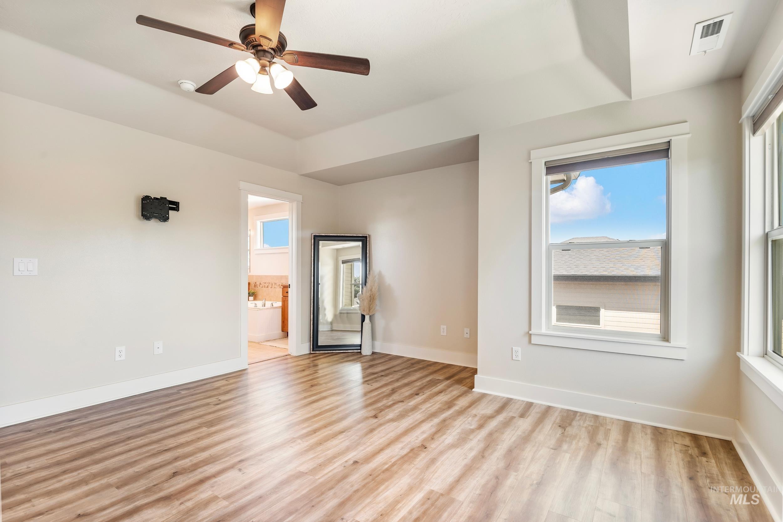 Empty room featuring light wood-style floors and a ceiling fan