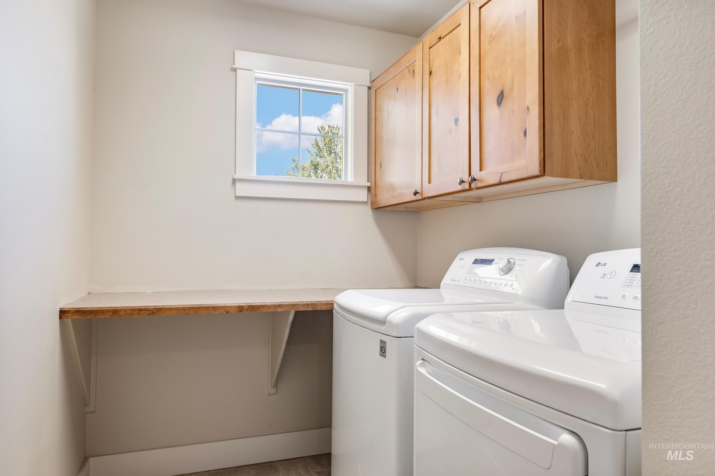 Washroom featuring washing machine and dryer and cabinet space