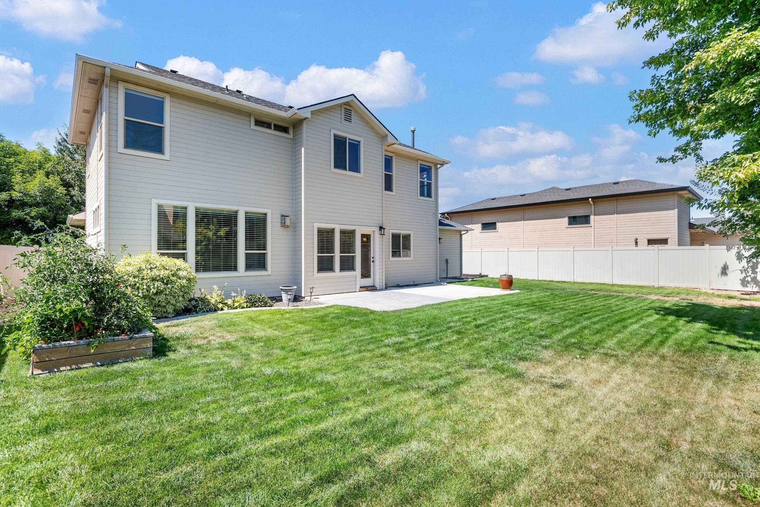 Rear view of house featuring a patio area and a vegetable garden