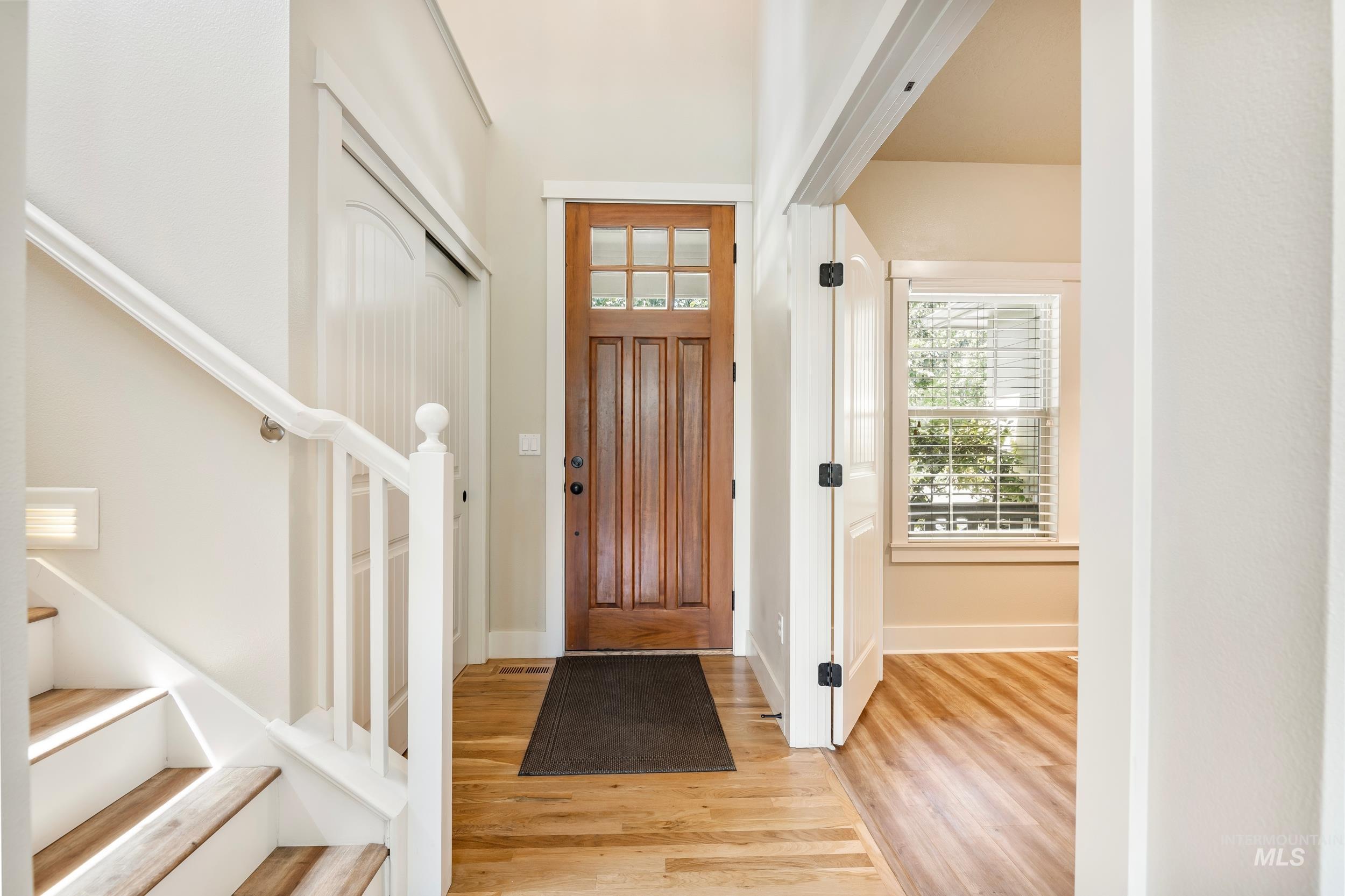 Foyer entrance featuring stairs and light wood-style floors