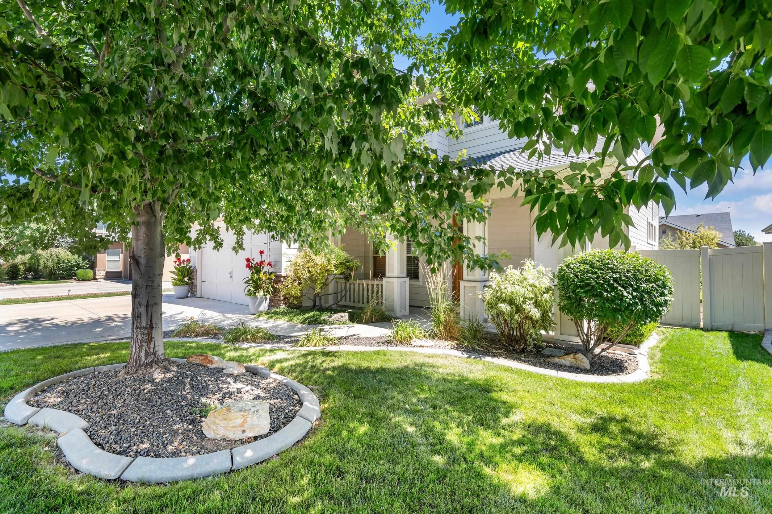 View of yard with concrete driveway, a garage, and a porch