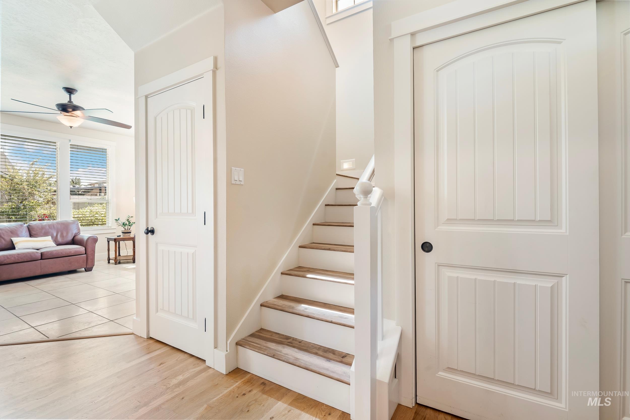 Staircase featuring wood finished floors and a ceiling fan