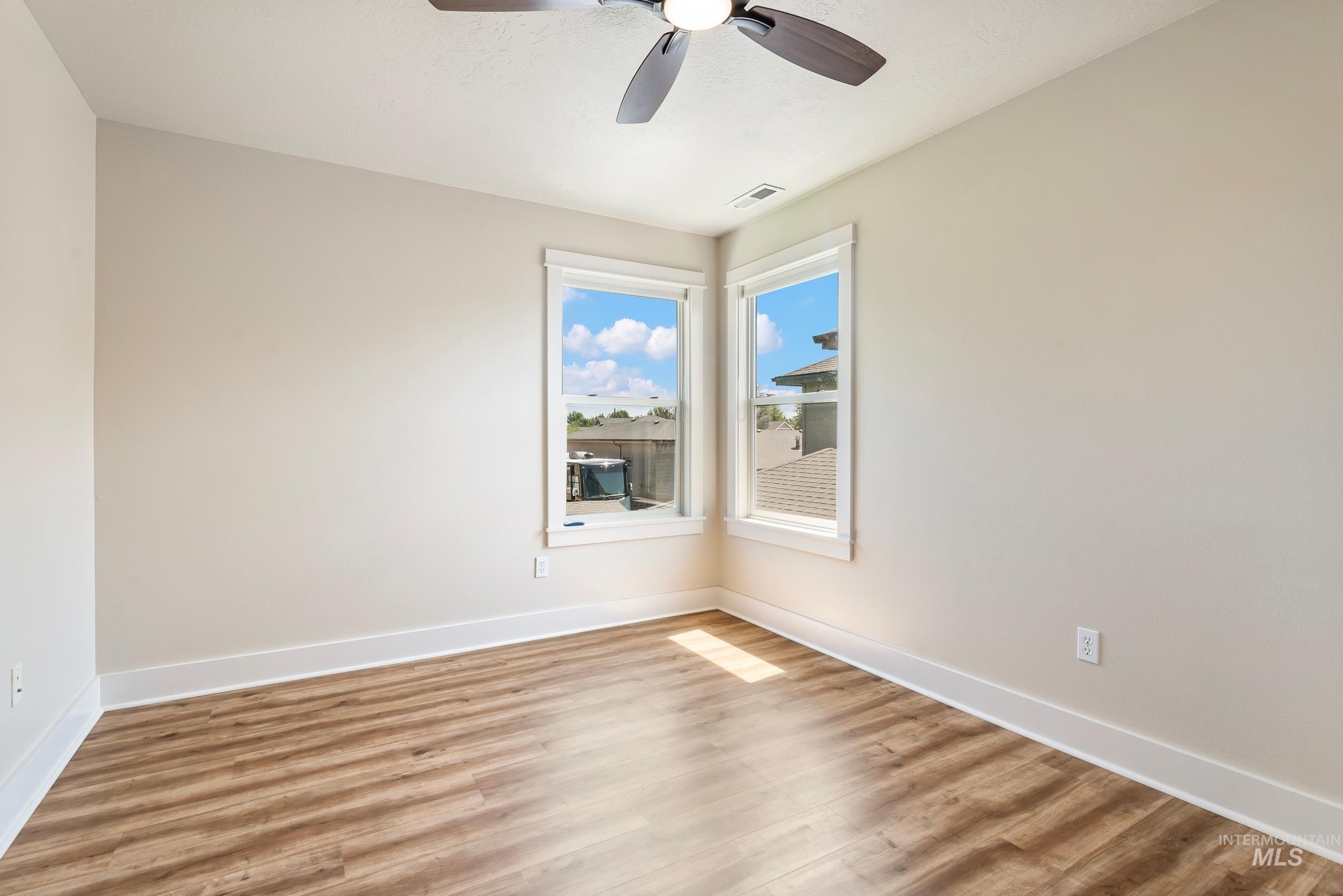 Empty room featuring wood finished floors and ceiling fan
