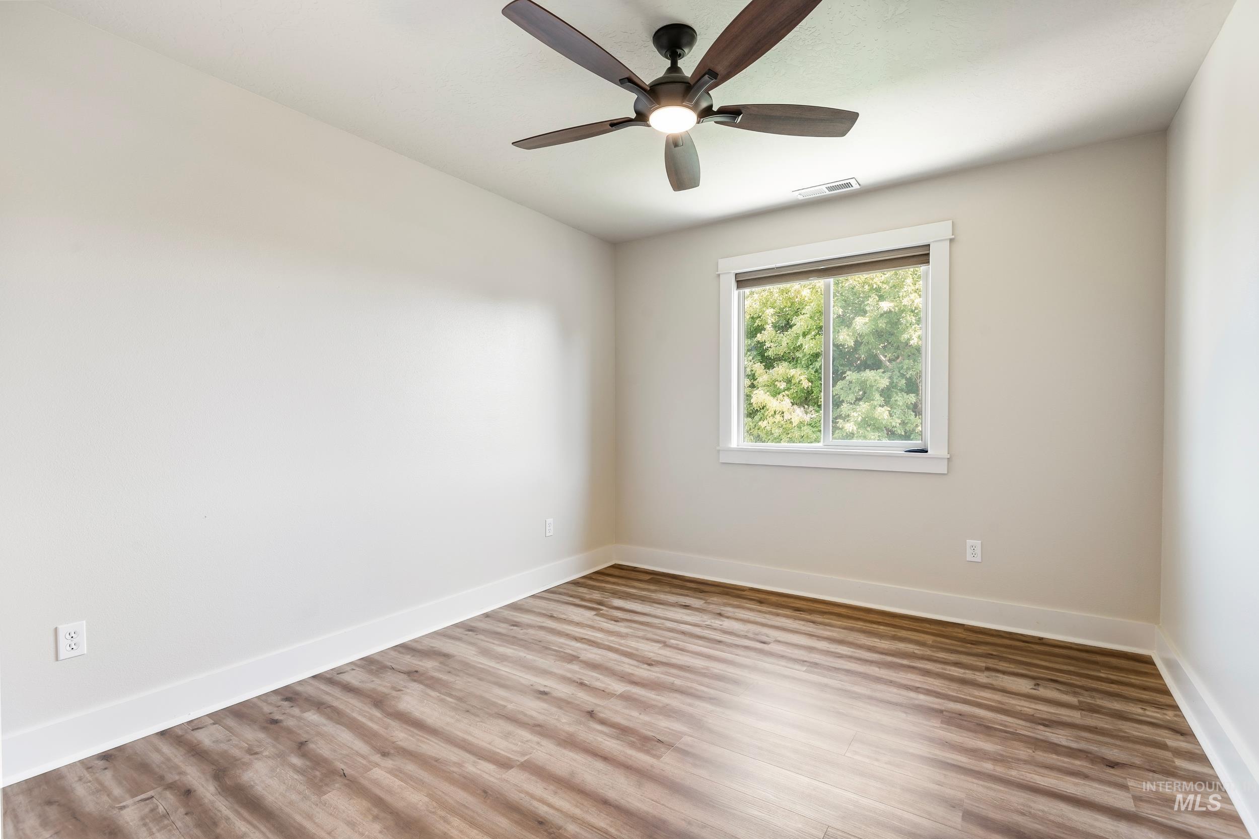 Unfurnished room with wood finished floors and ceiling fan