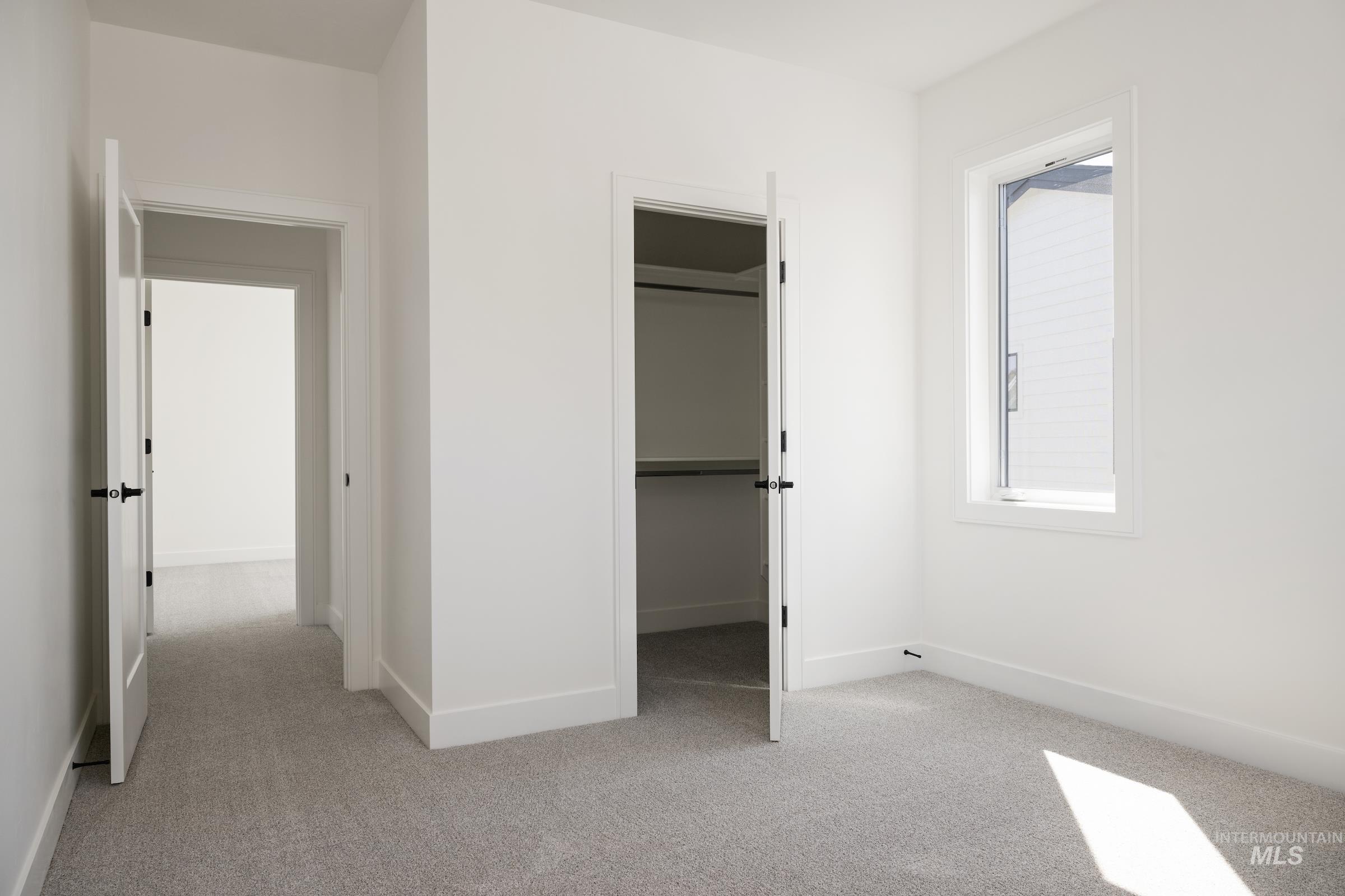 Unfurnished bedroom featuring light colored carpet and a spacious closet