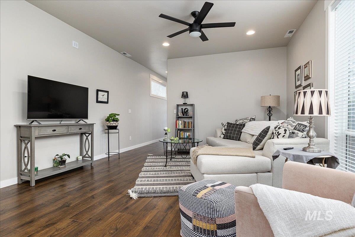 Living room featuring a ceiling fan, dark wood-style flooring, and recessed lighting