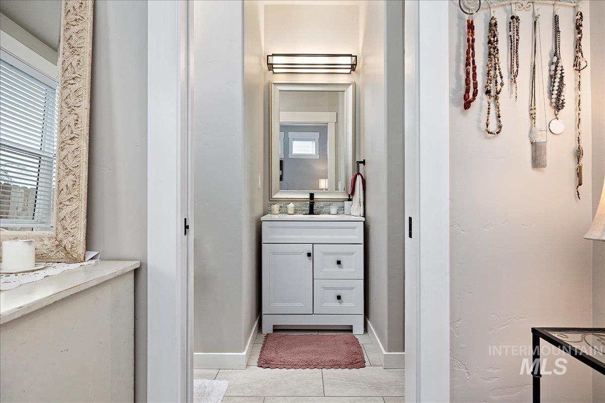 Half bath featuring vanity and light tile patterned floors