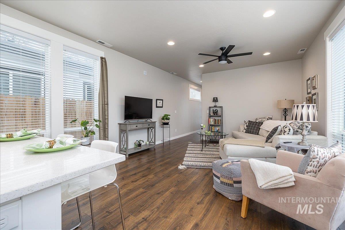 Living area with ceiling fan, dark wood-type flooring, and recessed lighting