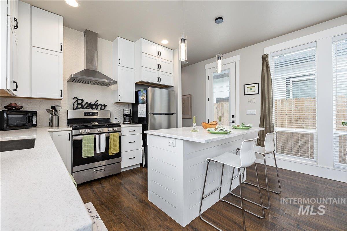 Kitchen featuring stainless steel appliances, white cabinets, and a breakfast bar area