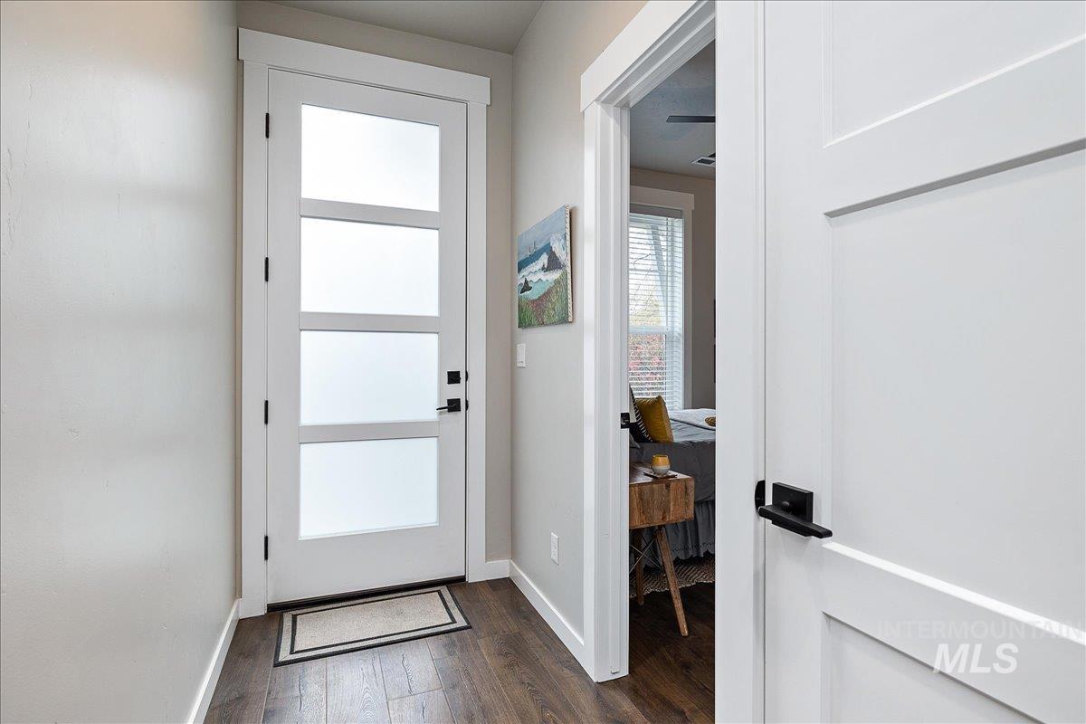 Doorway featuring hardwood / wood-style flooring and baseboards