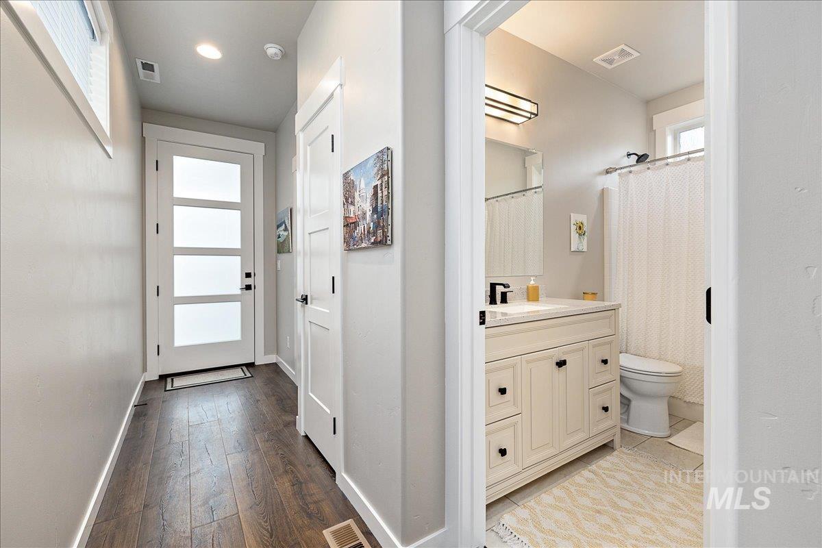 Bathroom featuring curtained shower, vanity, and light wood finished floors