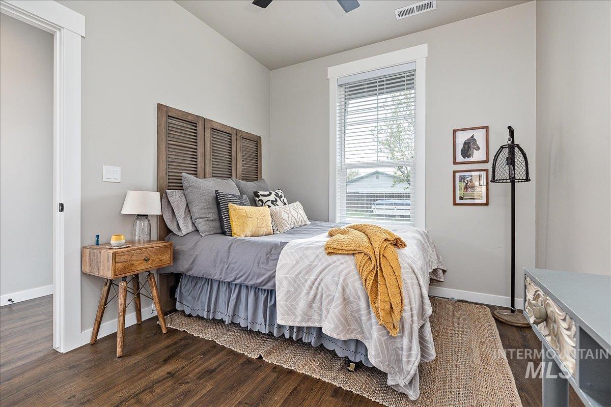 Bedroom with dark wood-style floors and a ceiling fan