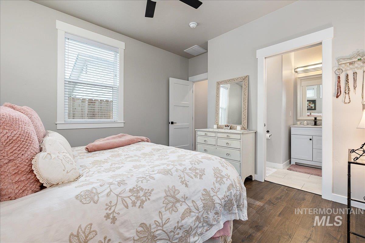 Bedroom featuring dark wood-type flooring, connected bathroom, and ceiling fan