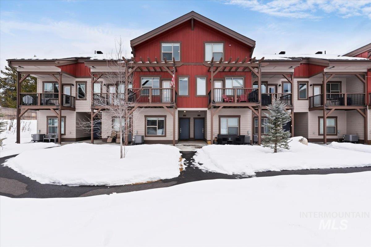 Snow covered back of property with a balcony