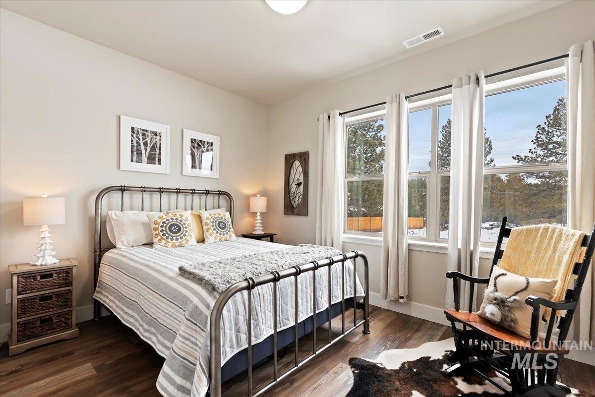 Bedroom with dark wood-style floors and baseboards