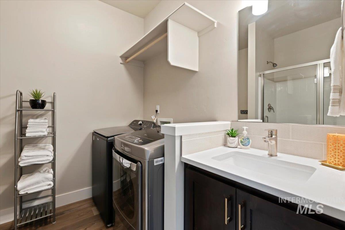 Laundry room with dark wood-style flooring and washer and clothes dryer