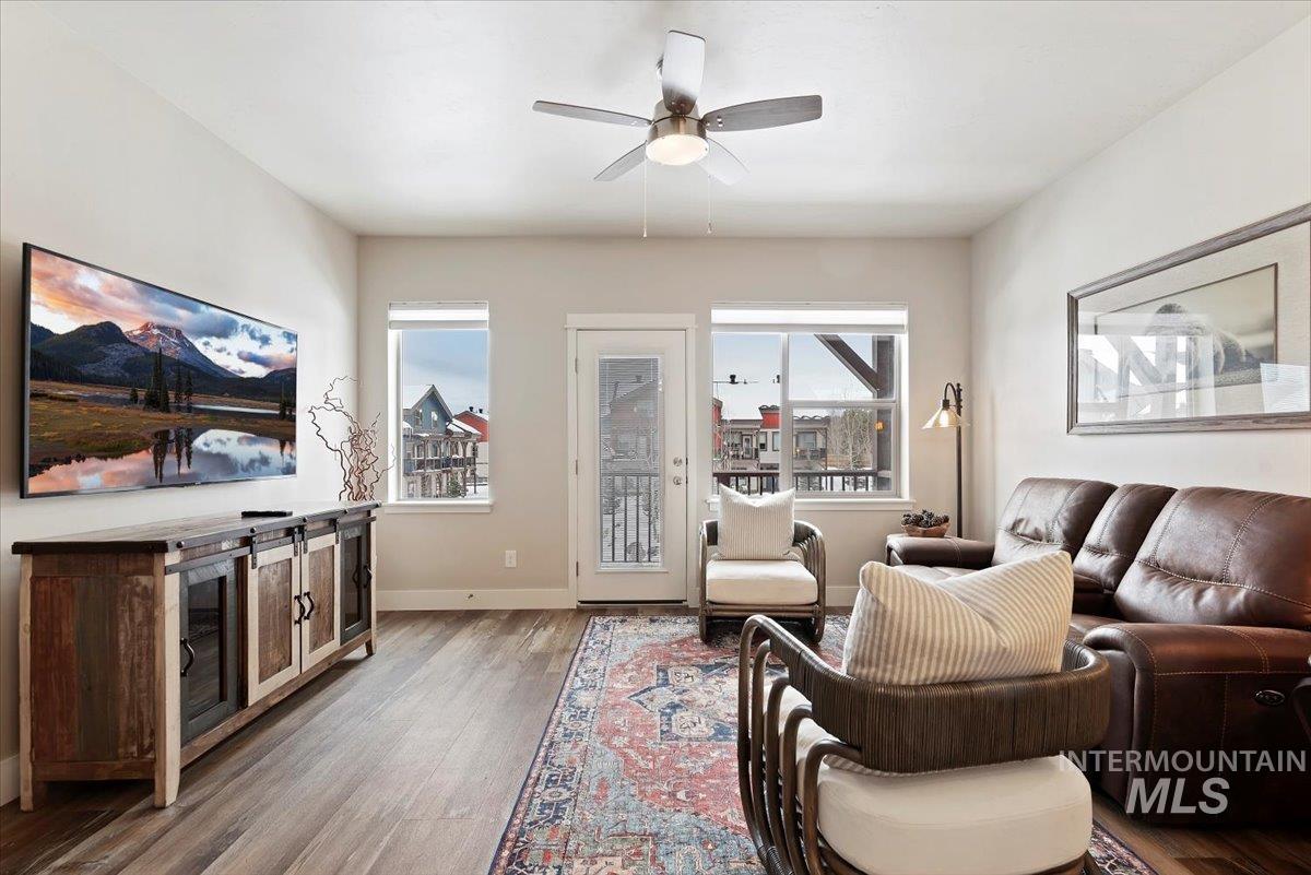 Living area with wood finished floors, a ceiling fan, and plenty of natural light