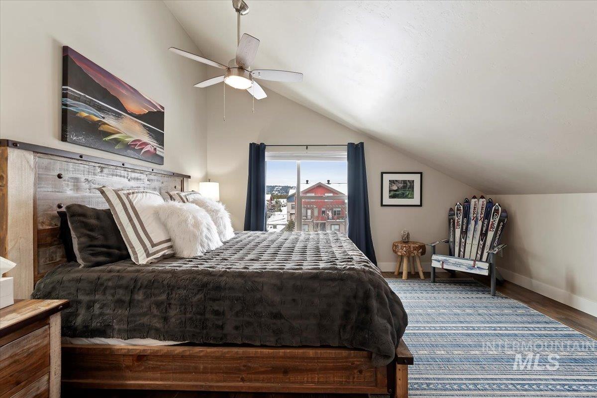 Bedroom with vaulted ceiling, wood finished floors, and ceiling fan