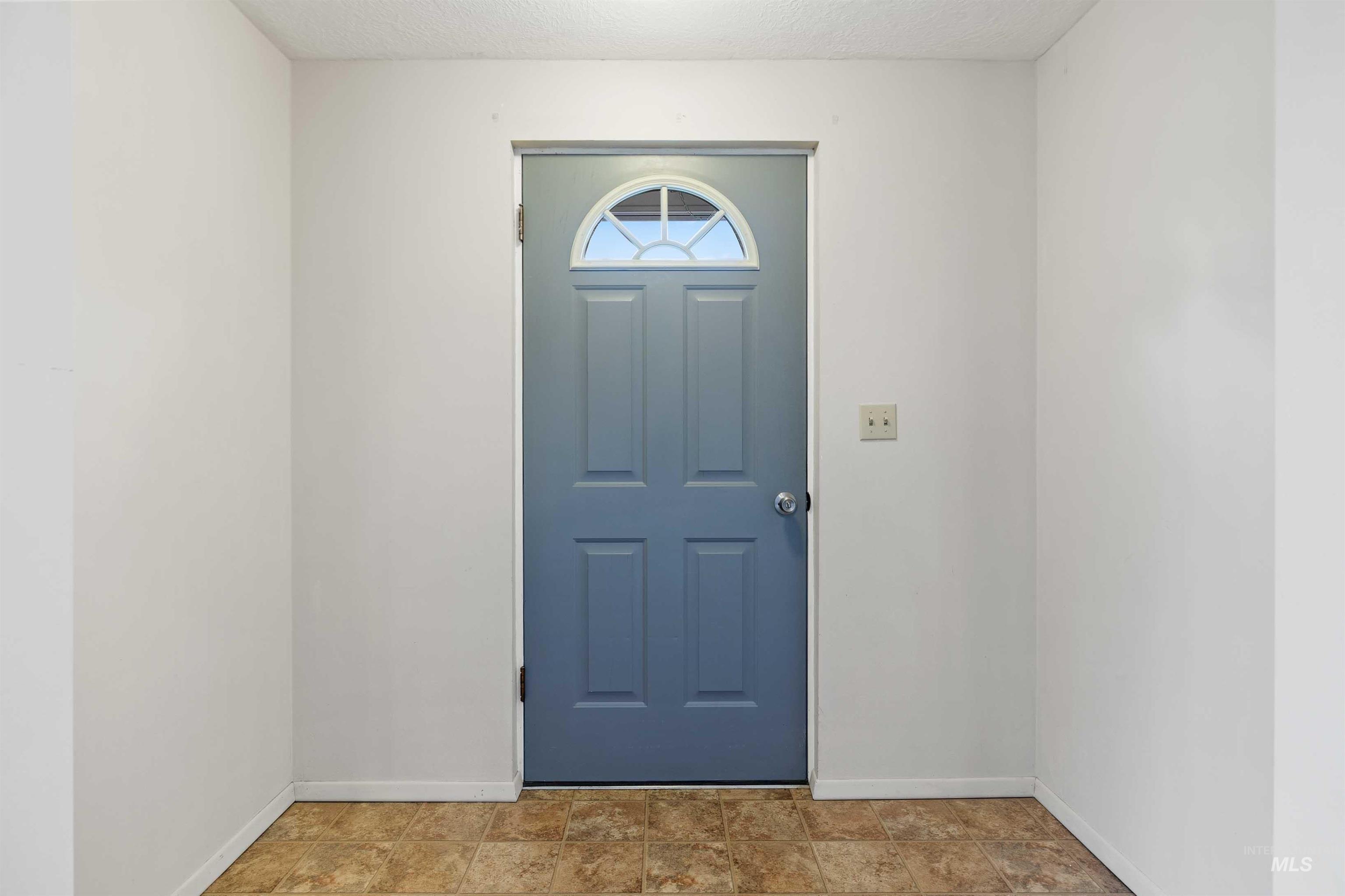 Foyer featuring baseboards and a textured ceiling