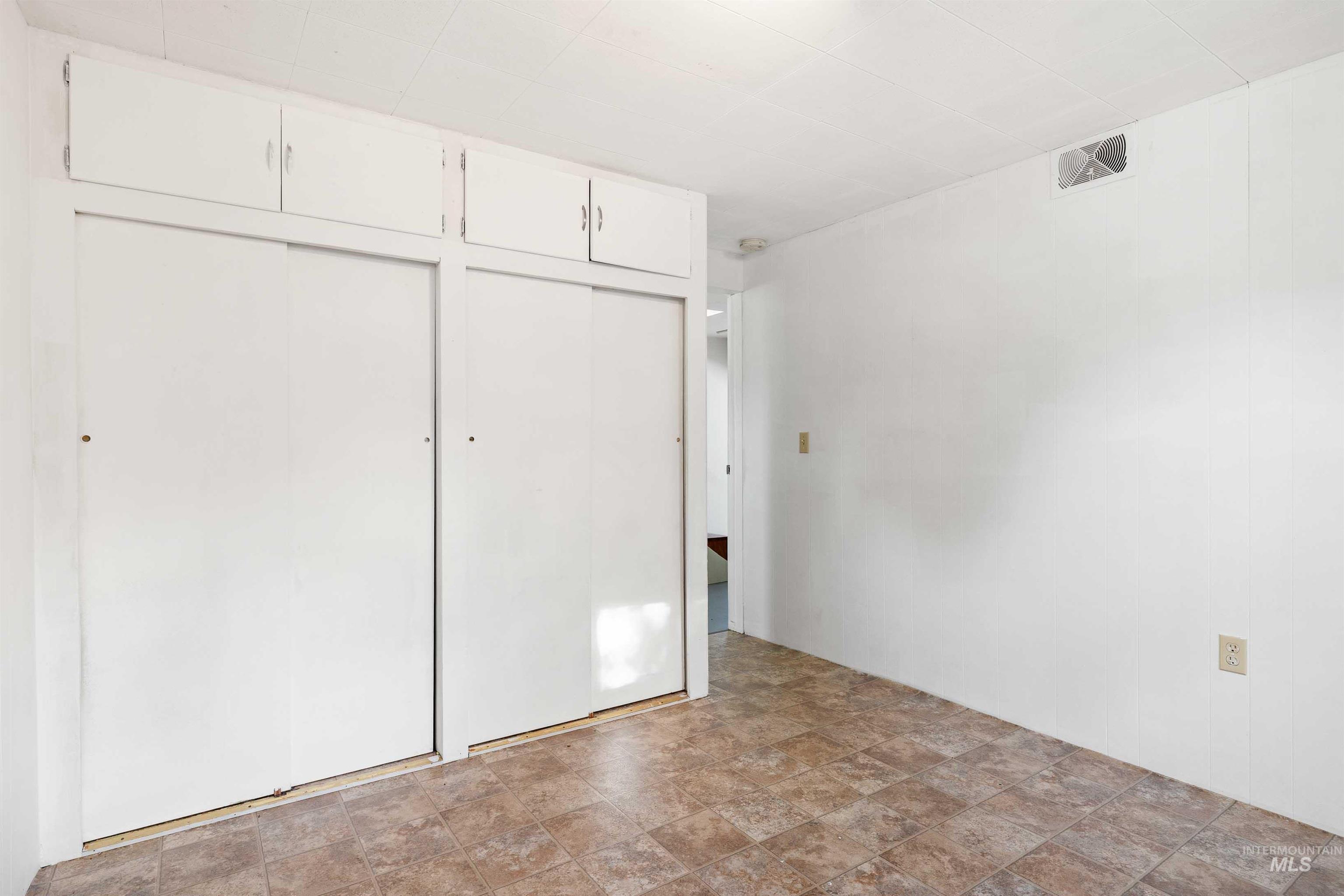 Unfurnished bedroom featuring a closet and stone finish flooring