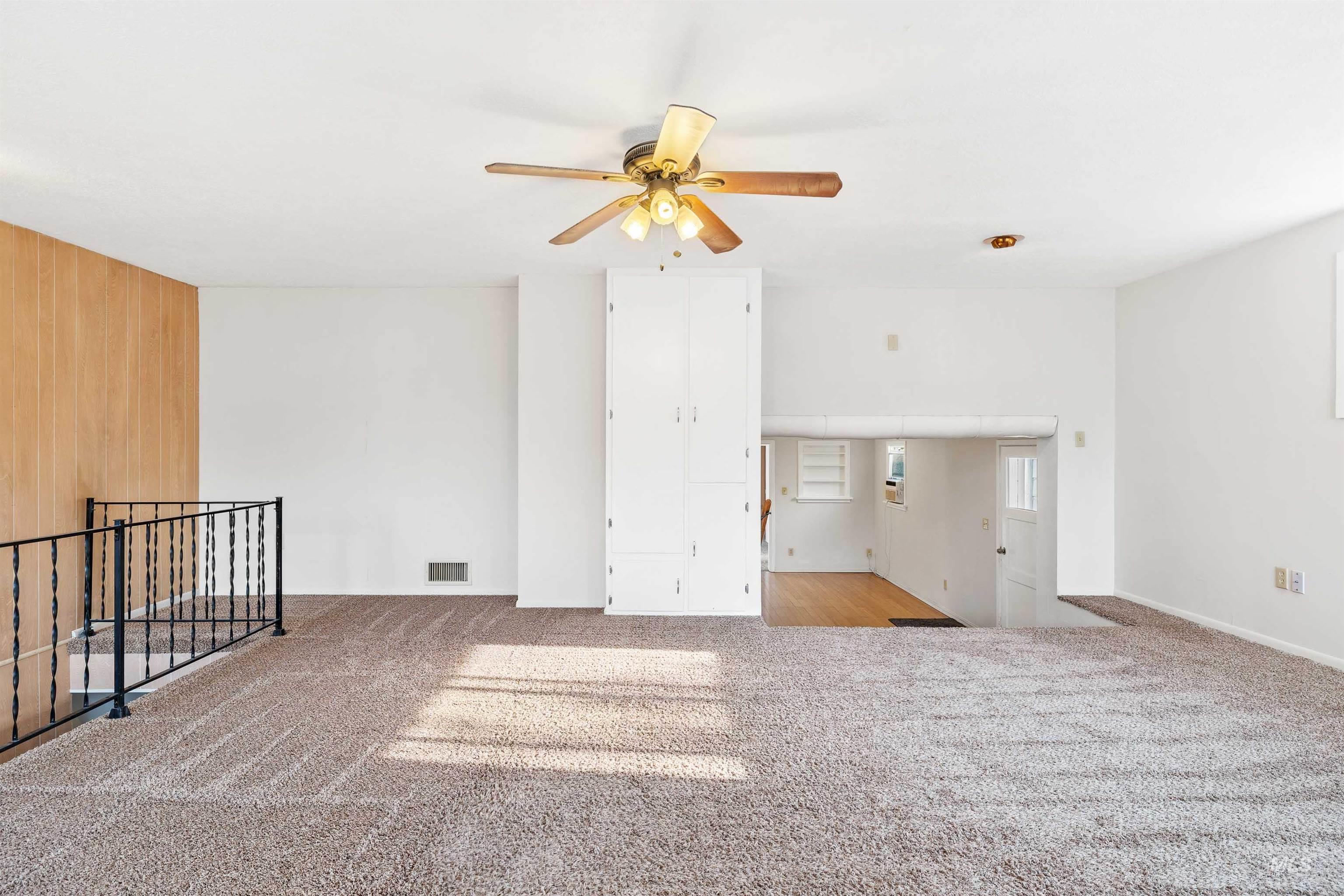 Spare room featuring light colored carpet and ceiling fan