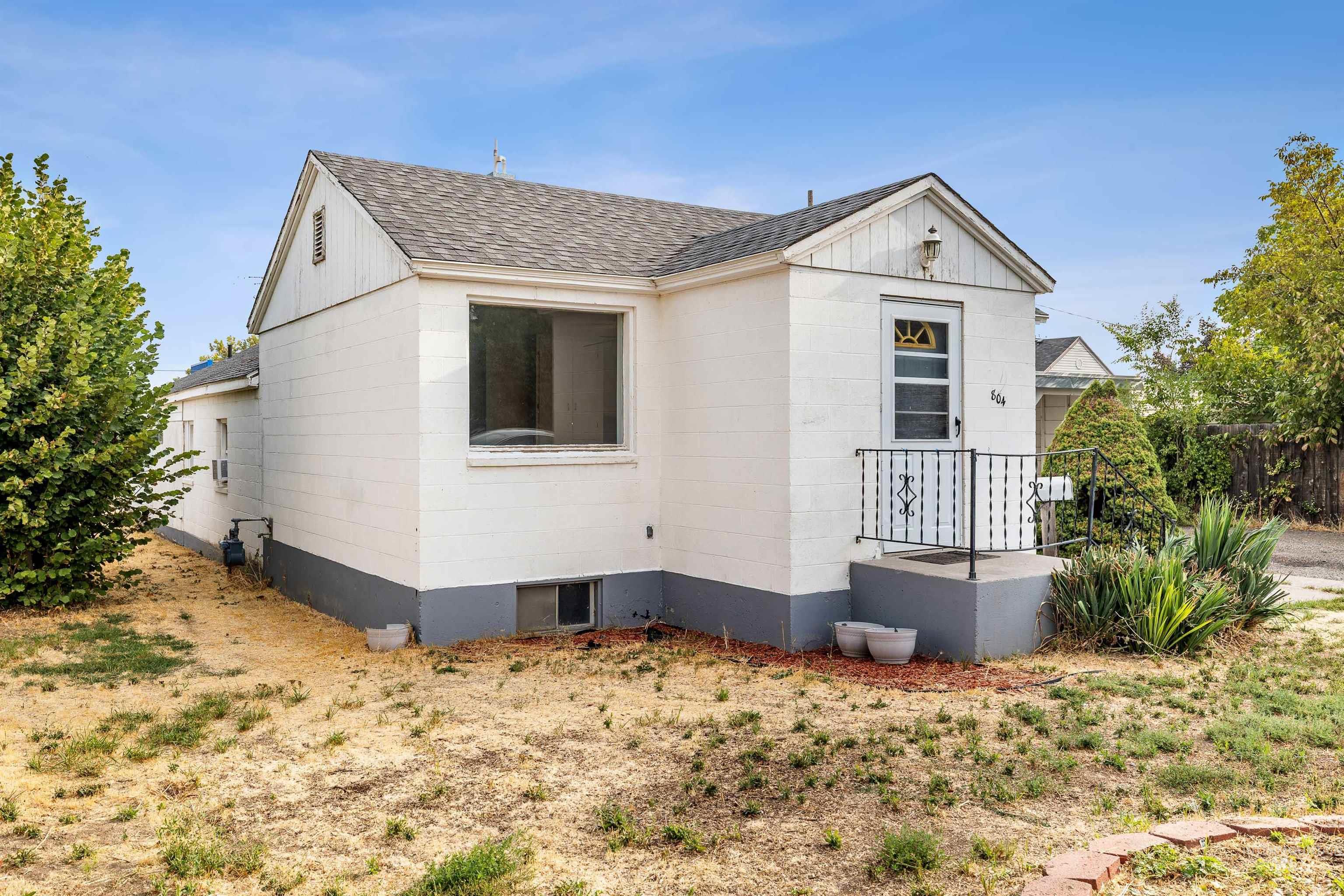 View of front of house featuring concrete block siding, a shingled roof, and board and batten siding