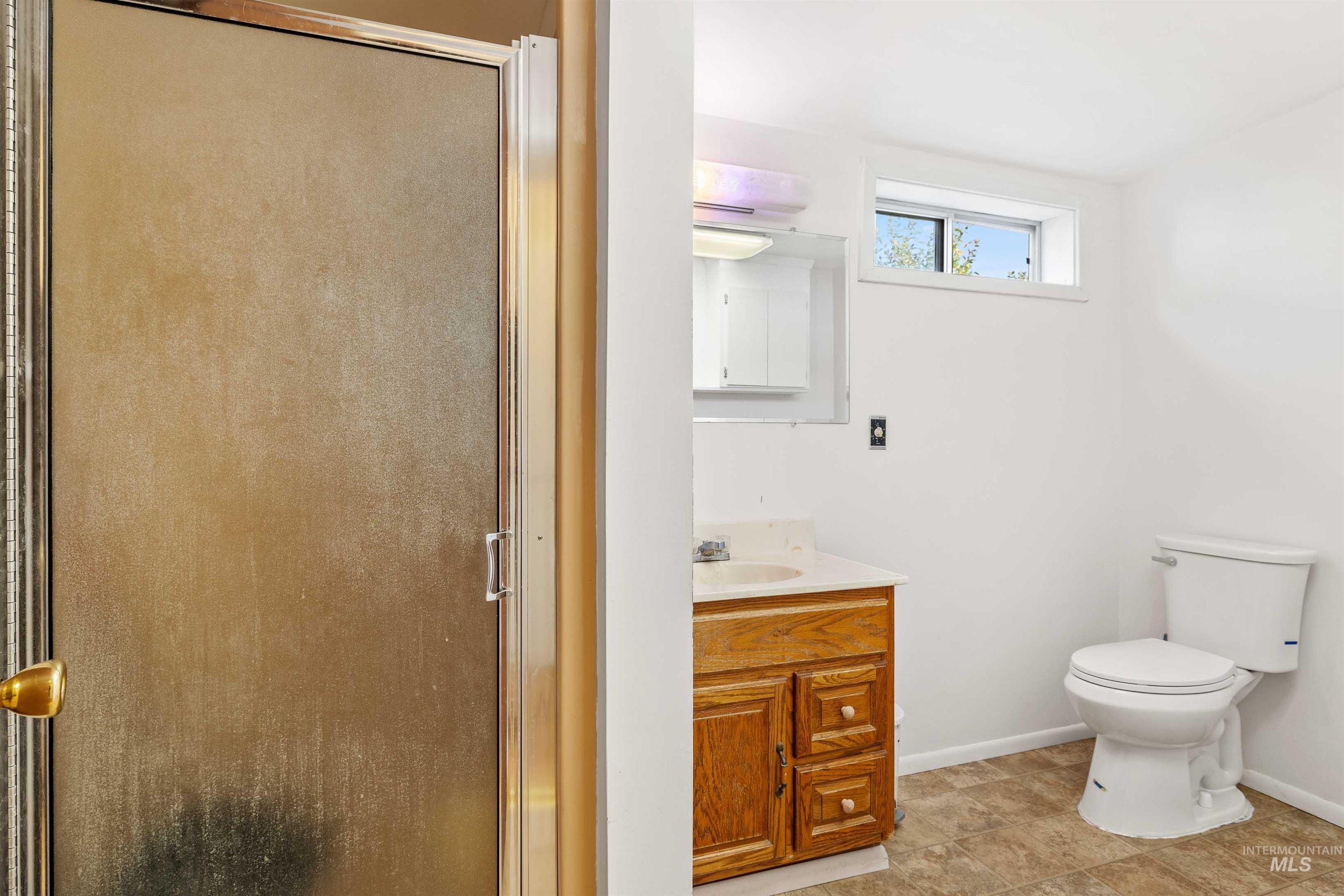 Full bath with a shower stall, vanity, and light tile patterned floors