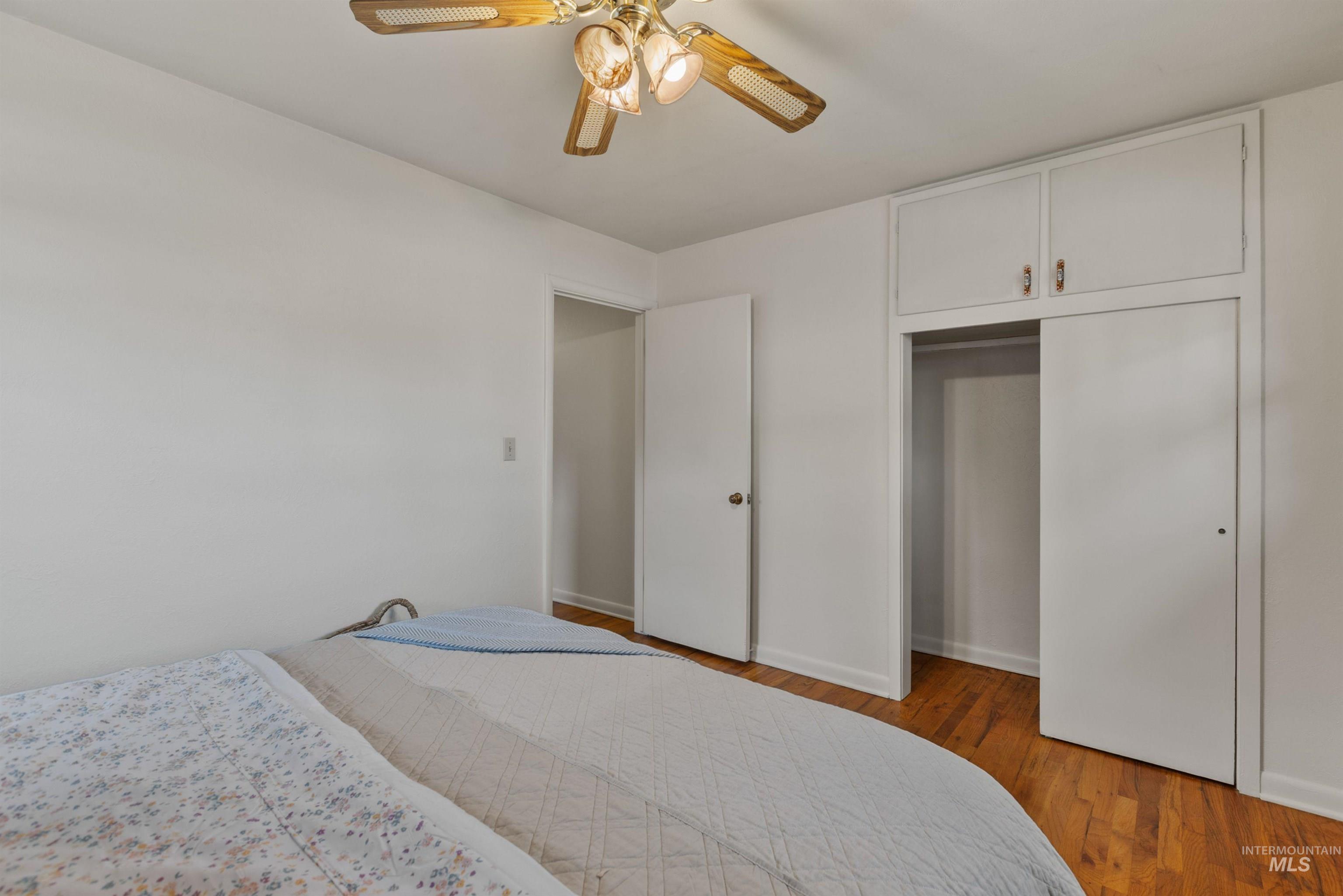 Bedroom with light wood-type flooring, ceiling fan, and a closet