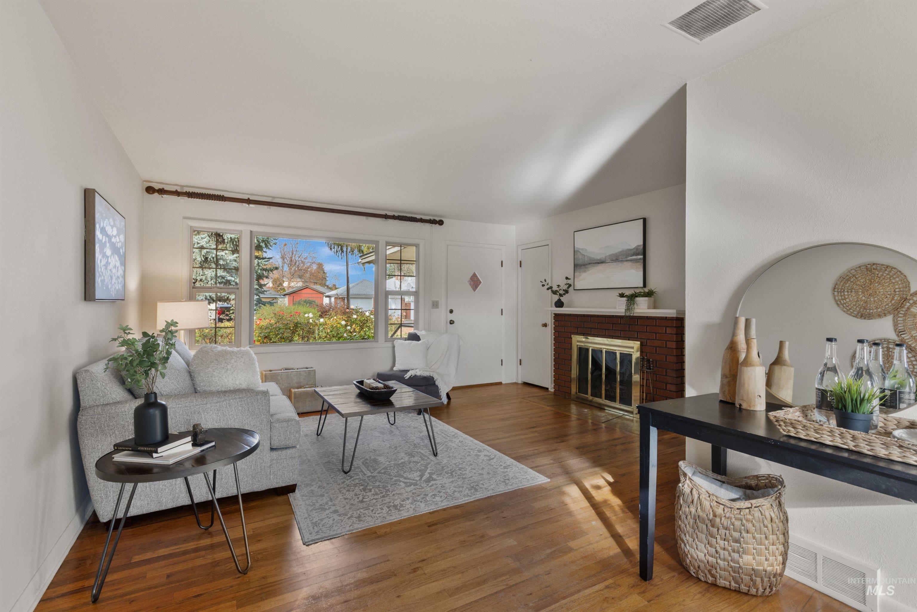 Living room with a brick fireplace and wood finished floors