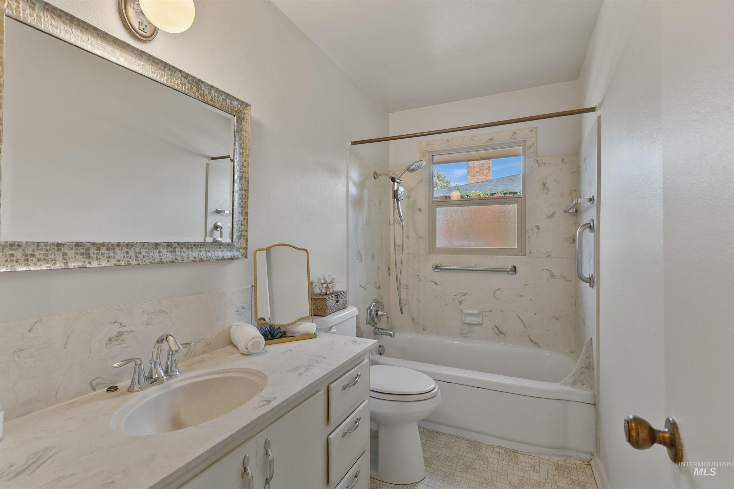 Full bath featuring vanity and washtub / shower combination