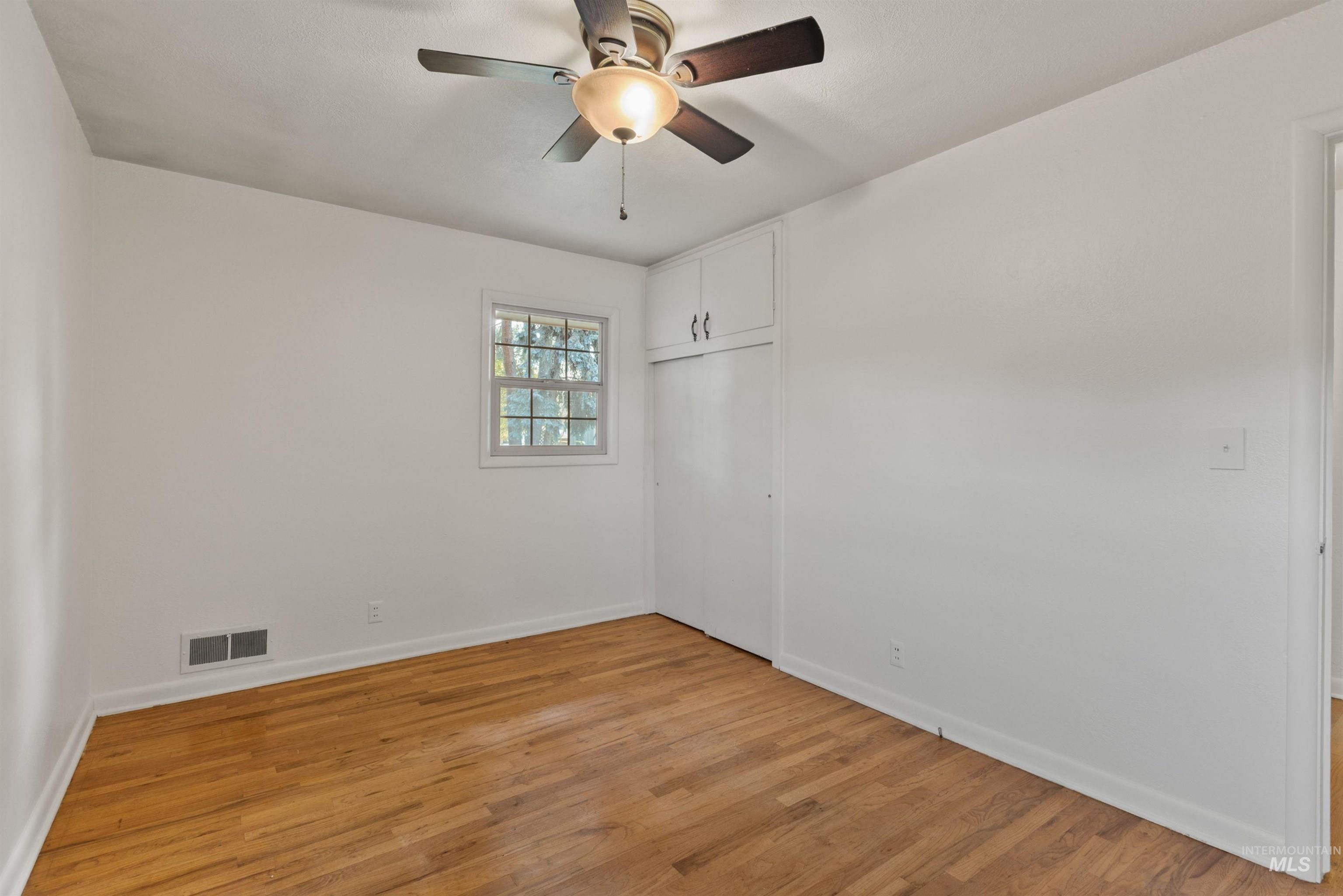 Spare room with light wood-type flooring and a ceiling fan