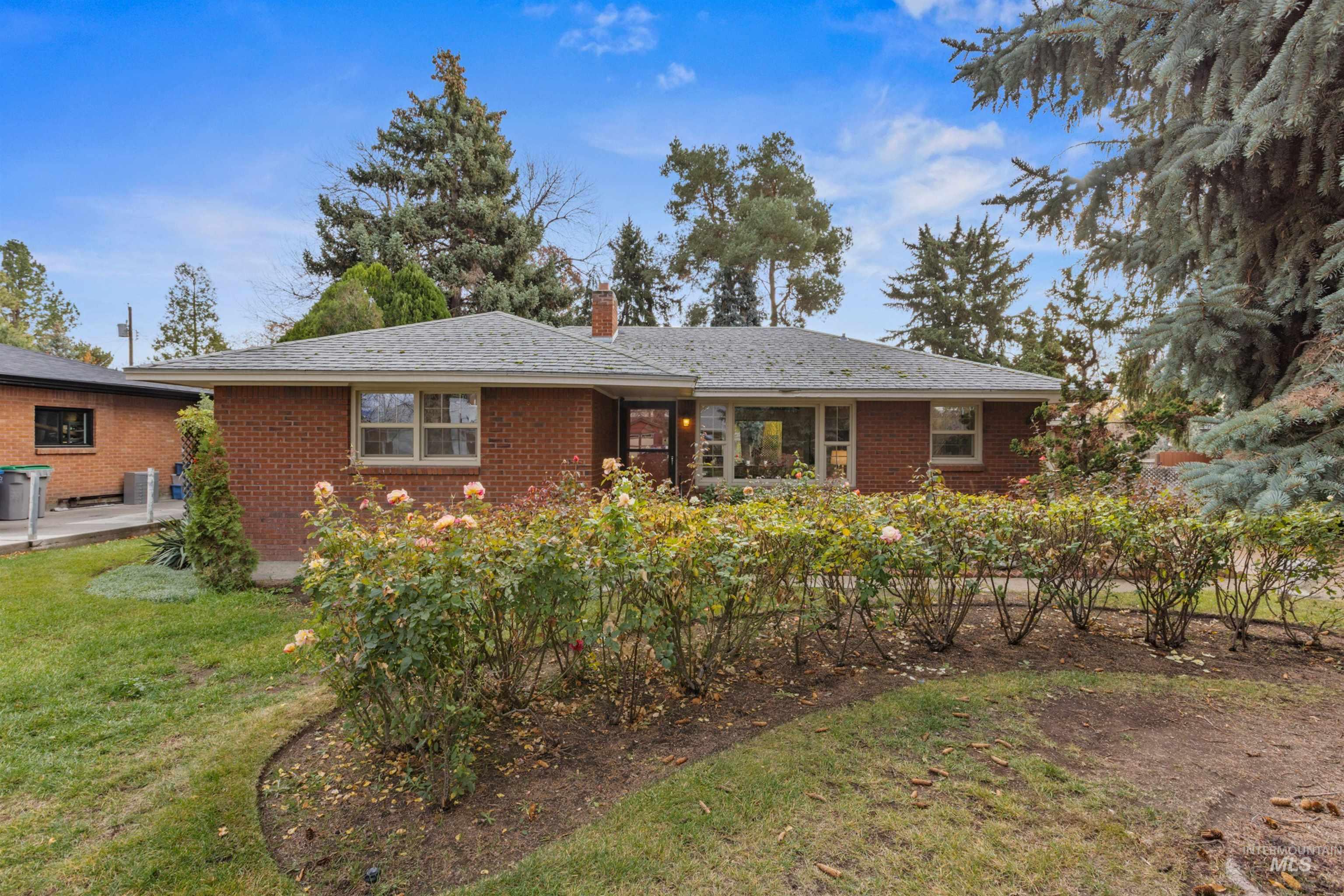 Ranch-style house with a chimney, brick siding, and a front yard