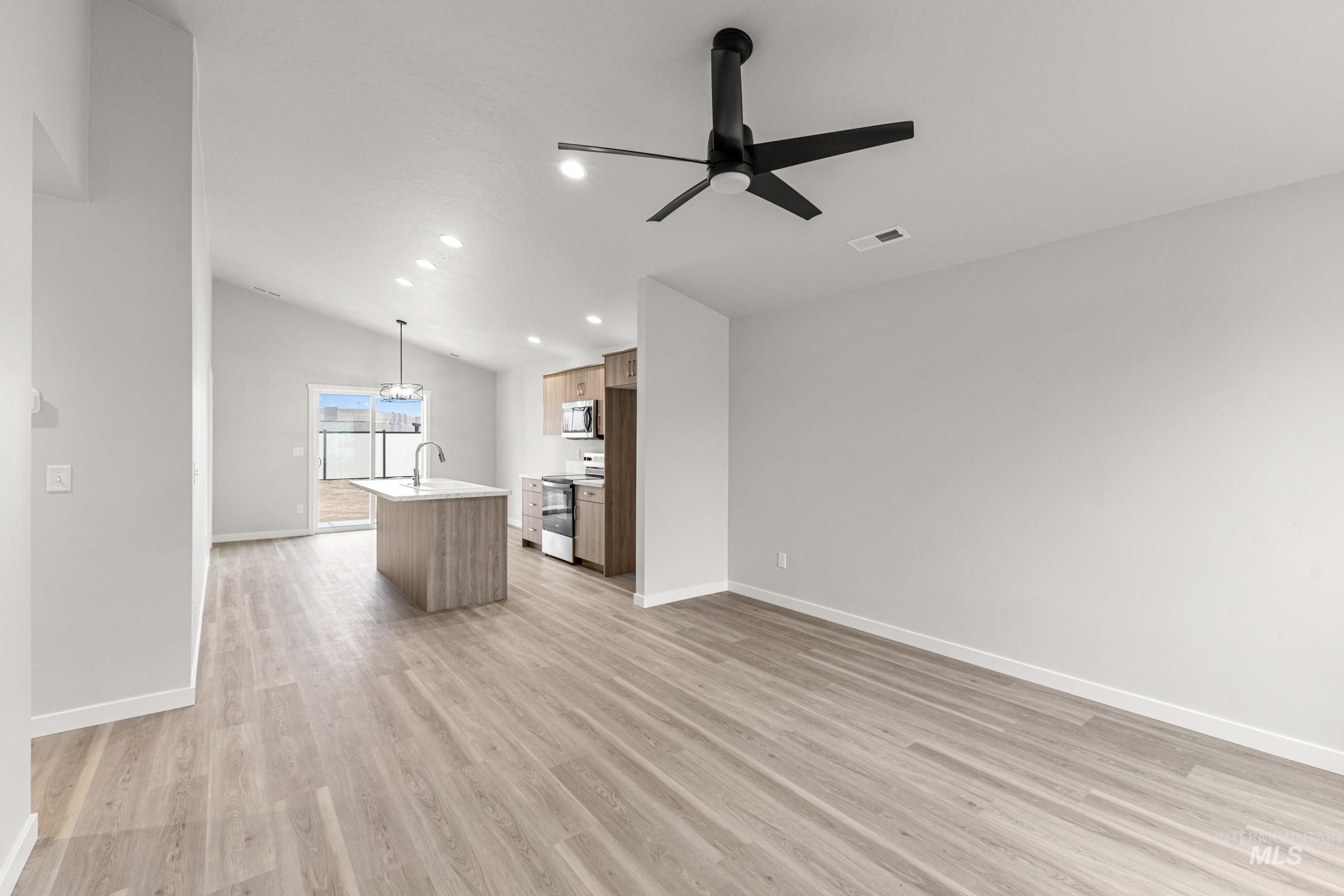 Open concept living space with vaulted ceilings, wood-finish flooring, recessed lighting, and a contemporary ceiling fan