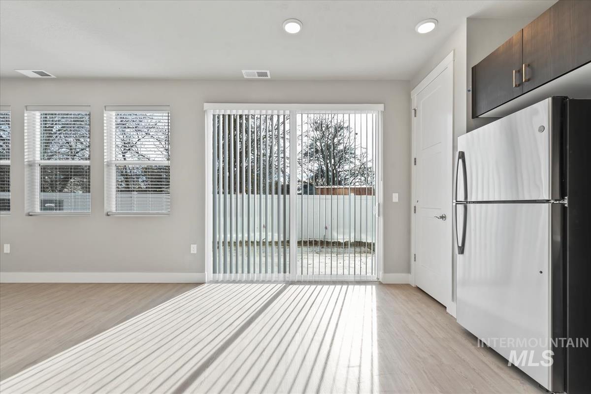 Kitchen with freestanding refrigerator, light wood-type flooring, plenty of natural light, and recessed lighting