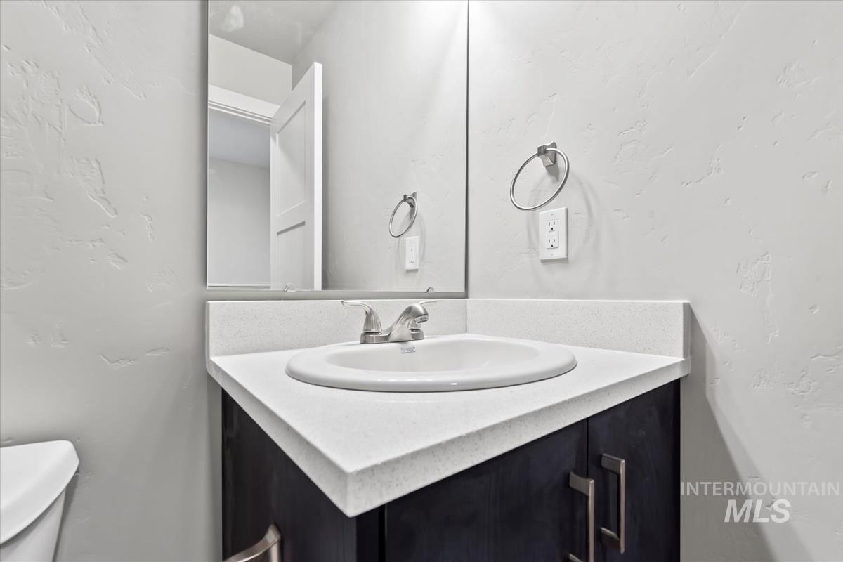 Bathroom with a textured wall and vanity