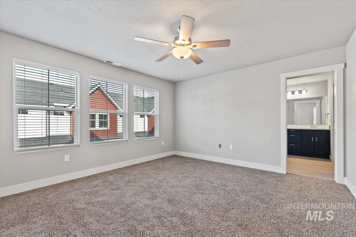 Spare room with light carpet, a textured ceiling, and ceiling fan