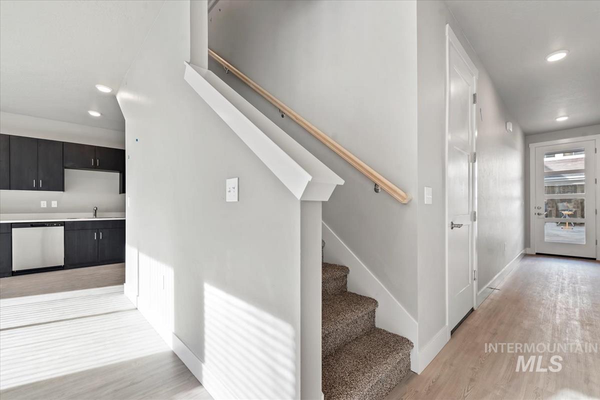 Stairs featuring recessed lighting and wood finished floors