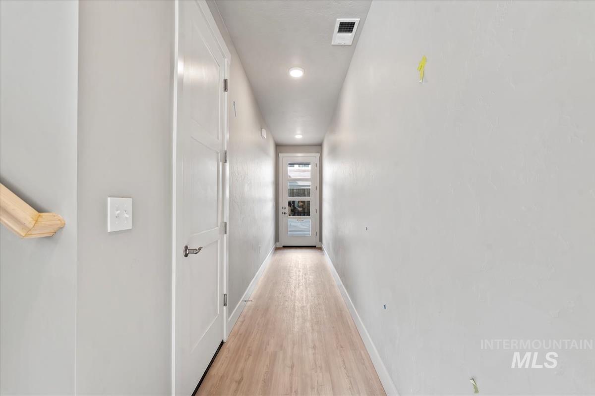 Corridor featuring light wood-type flooring and recessed lighting
