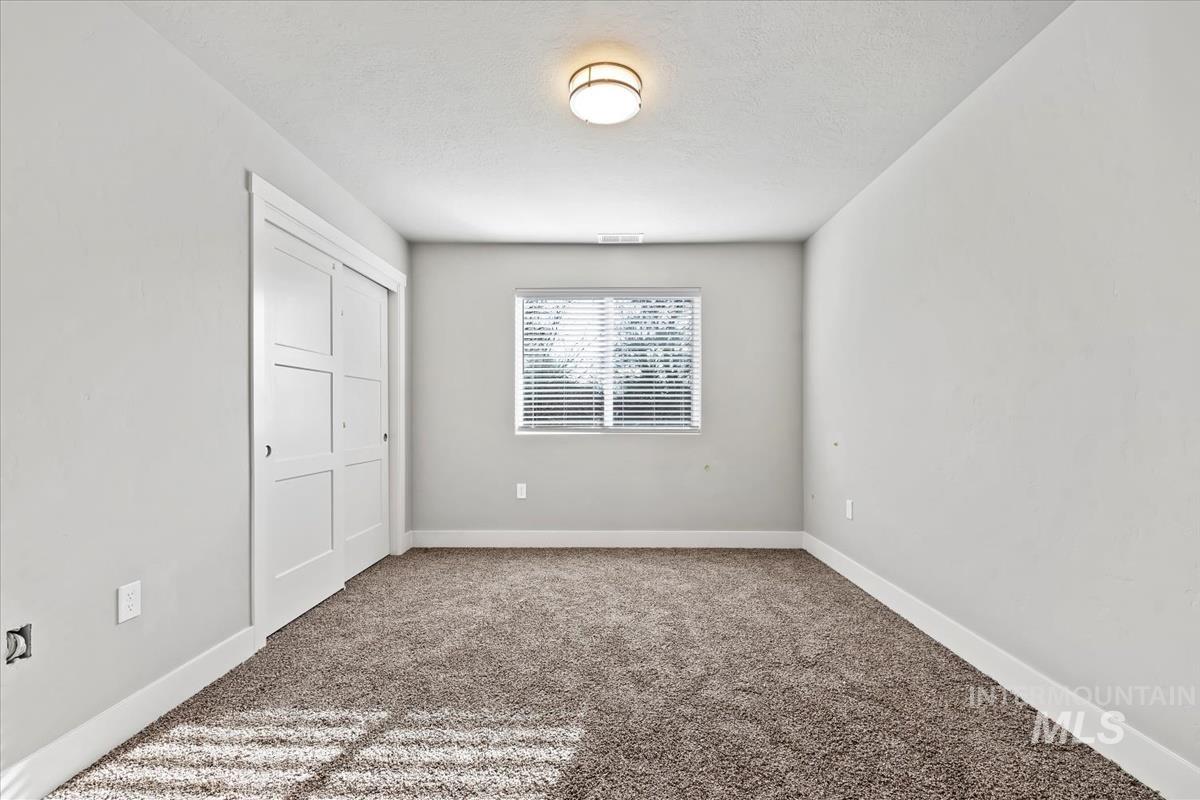 Unfurnished bedroom featuring carpet, a closet, and a textured ceiling