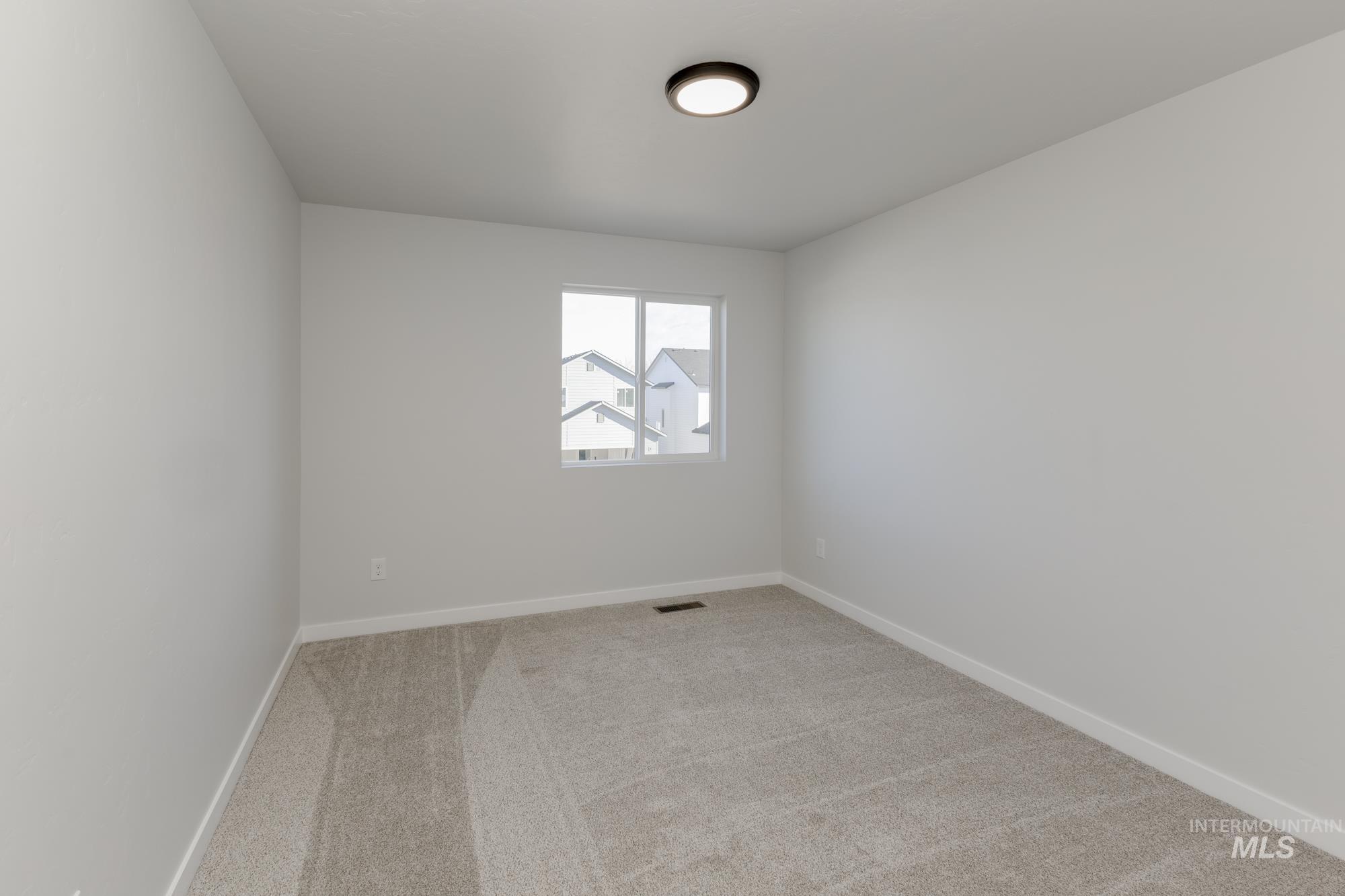 Spare room featuring baseboards and light colored carpet